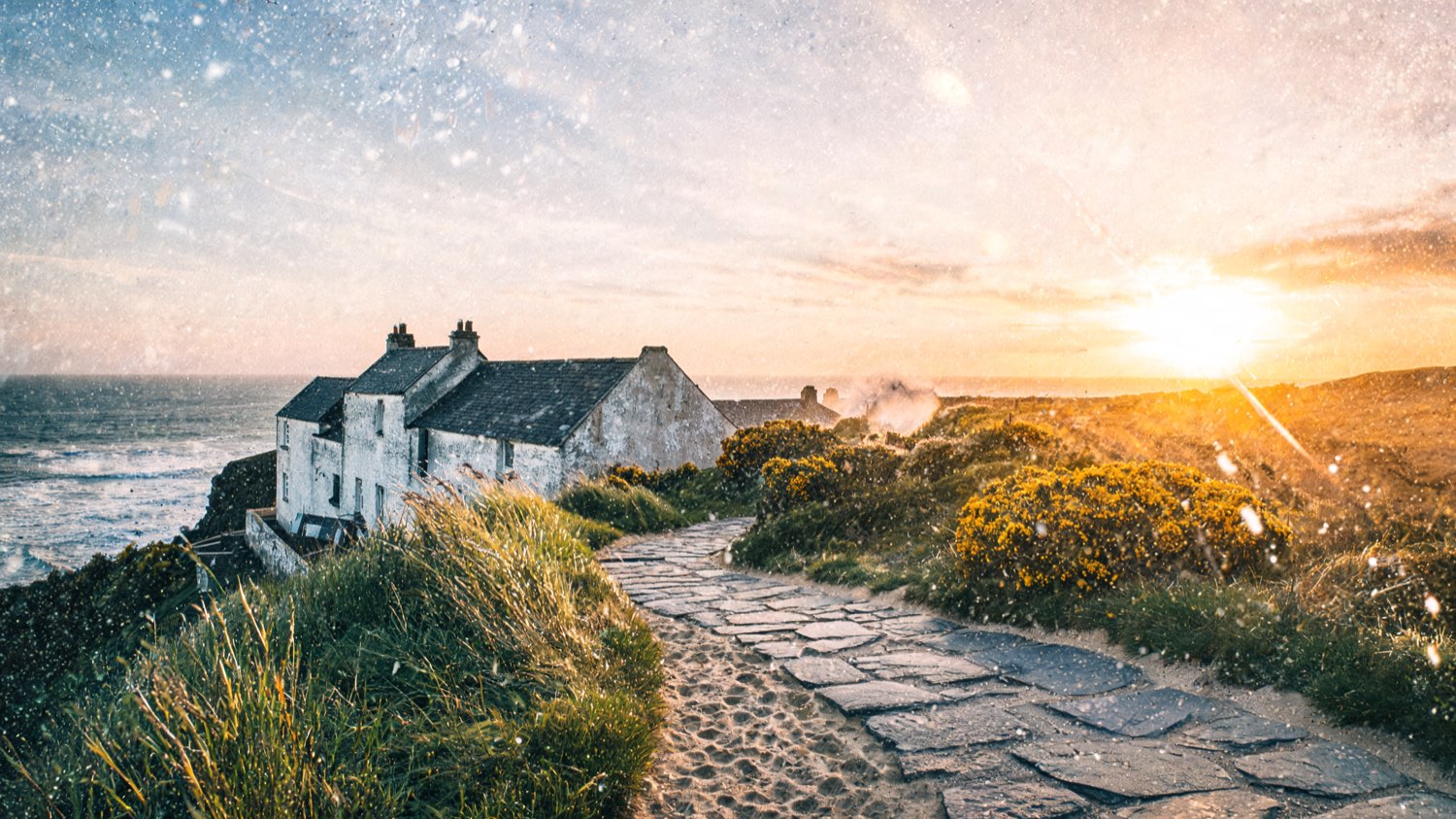 Whitewashed stone resort on a Cornwall clifftop at golden hour
